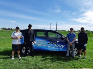 Golfers standing by Jani-King car