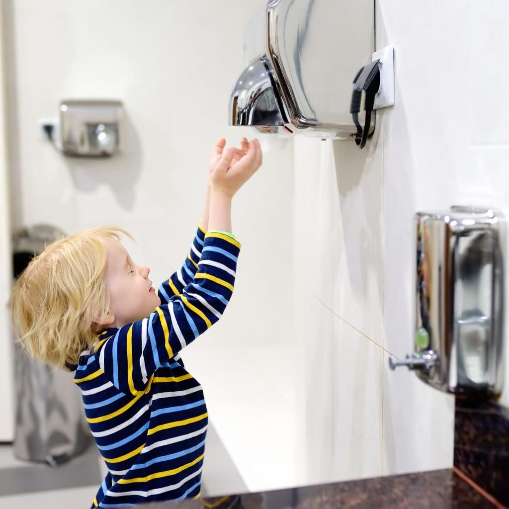 Little boy using air dryer