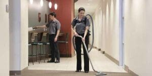 Jani-King Franchisee cleans carpets in commercial hallway